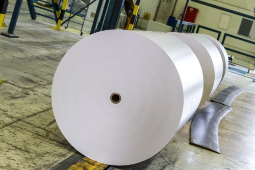 A stack of high-gloss C1S paper sheets reflecting light
