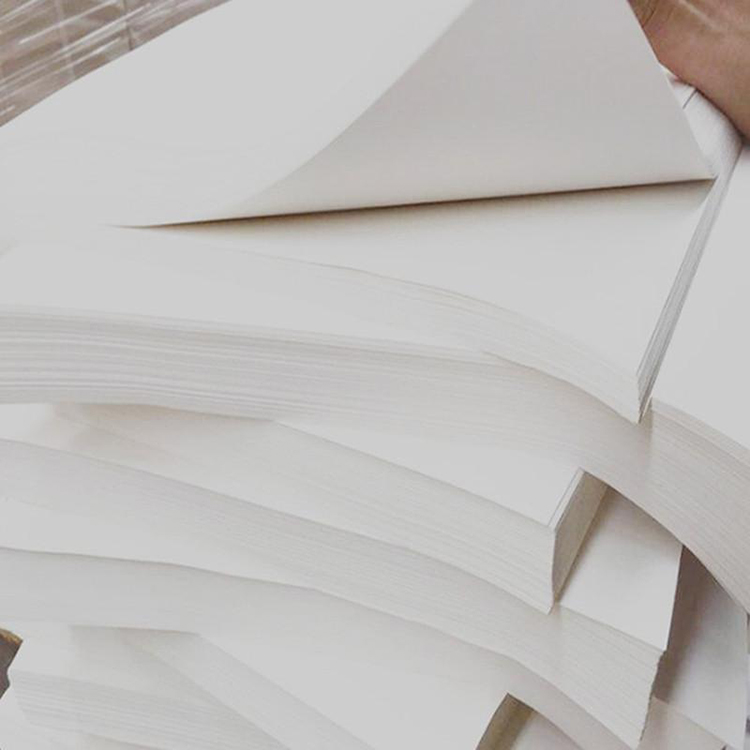 A stack of precisely cut sheets of hard white offset paper
